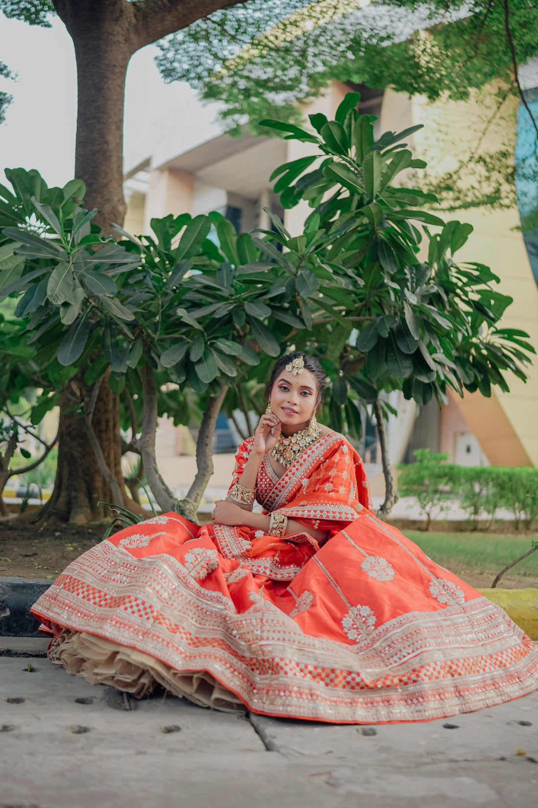 Woman in traditional indian attire sitting outdoors.