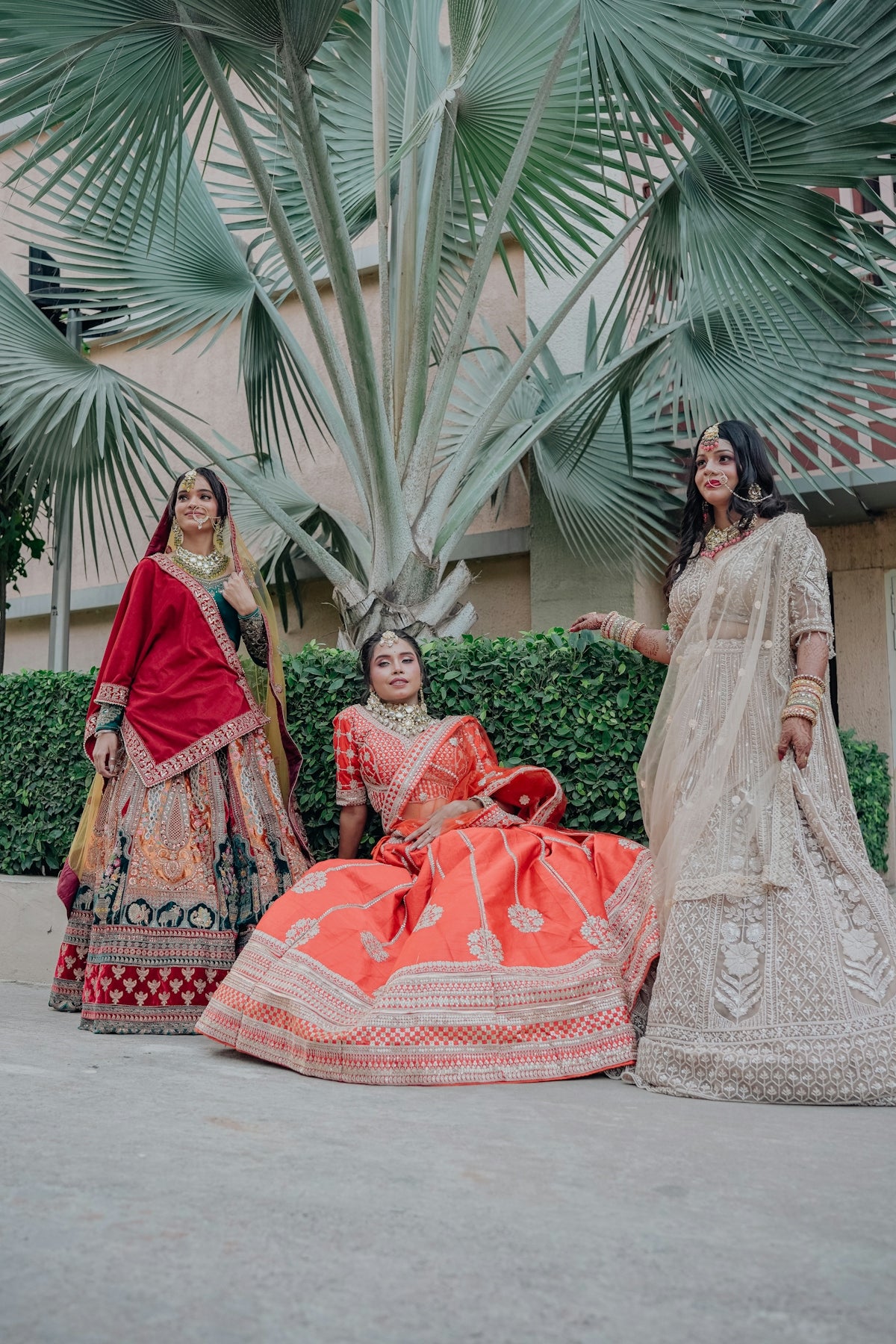 Three women in traditional indian wedding attire.
