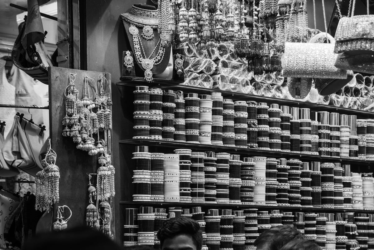 Shelves filled with bangles and jewelry at a market.