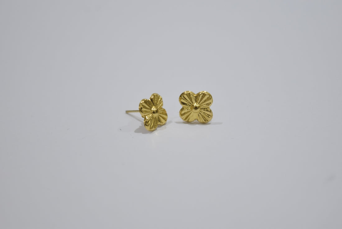 Two gold stud earrings with floral design
