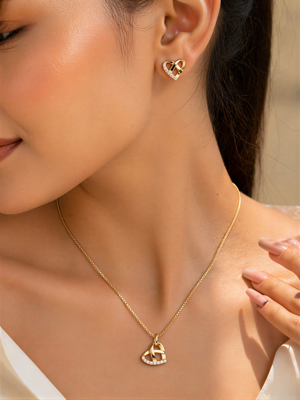 Woman wearing gold plated heart pendant necklace and earrings set