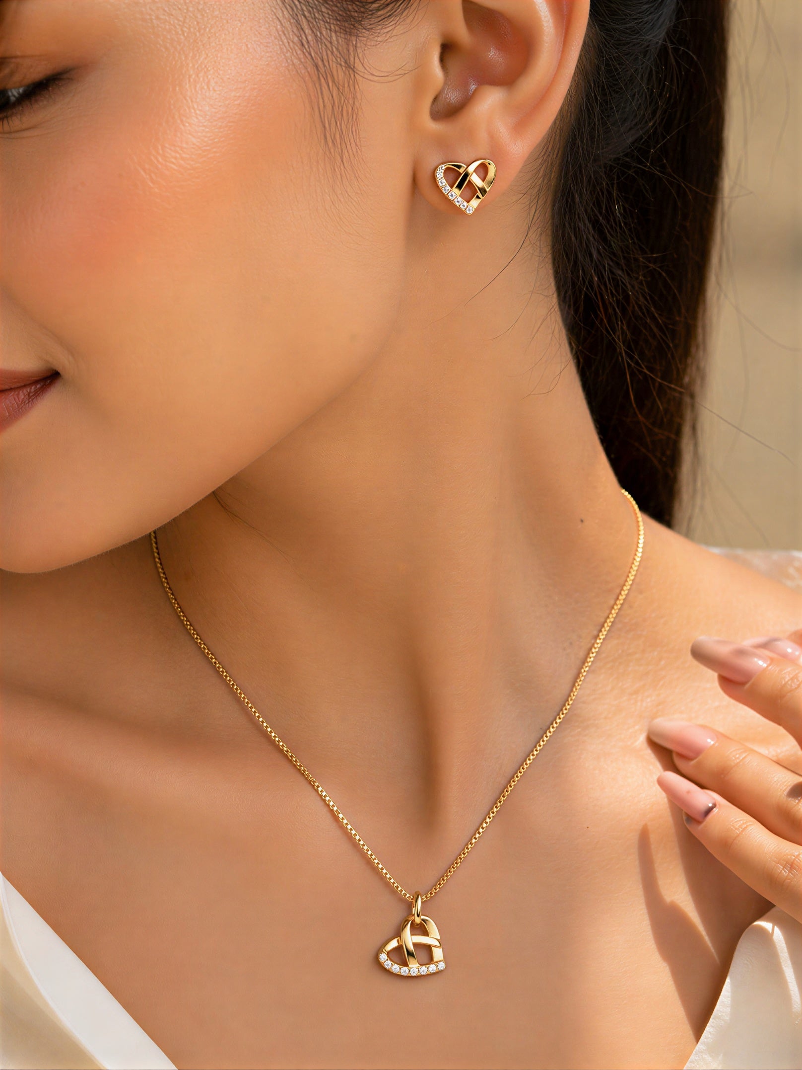 Woman wearing gold plated heart pendant necklace and earrings set