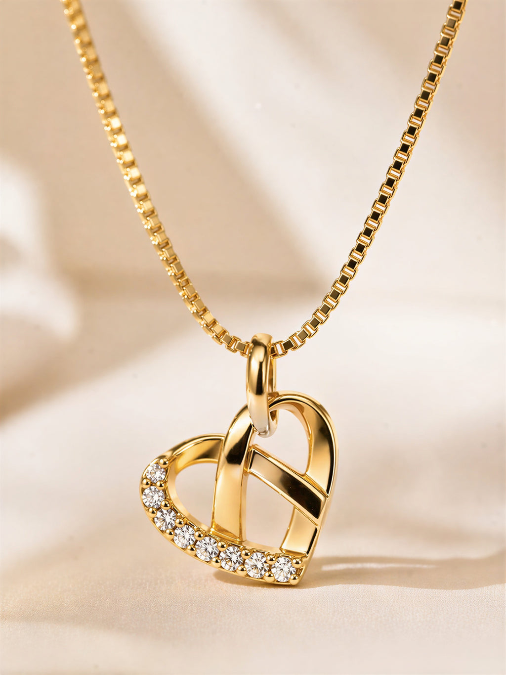 Close-up gold plated heart pendant with crystal detailing
