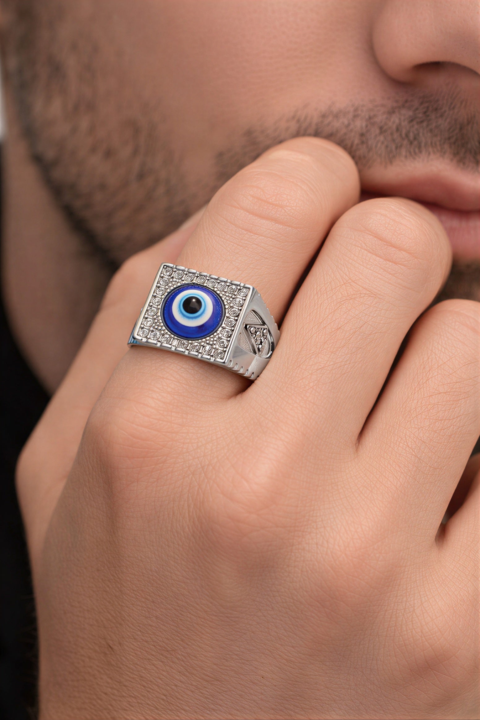 Close-up of men’s evil eye ring with blue stone and CZ crystals, square oxidised stainless steel fashion ring