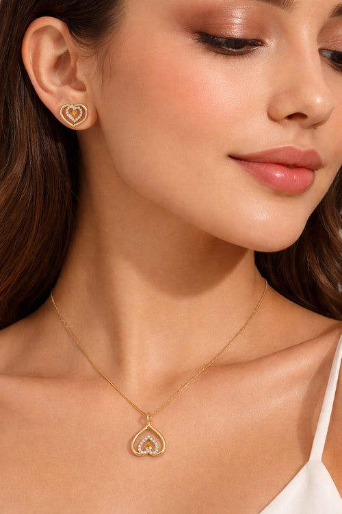 woman wearing gold plated heart pendant necklace and earrings jewellery set closeup look